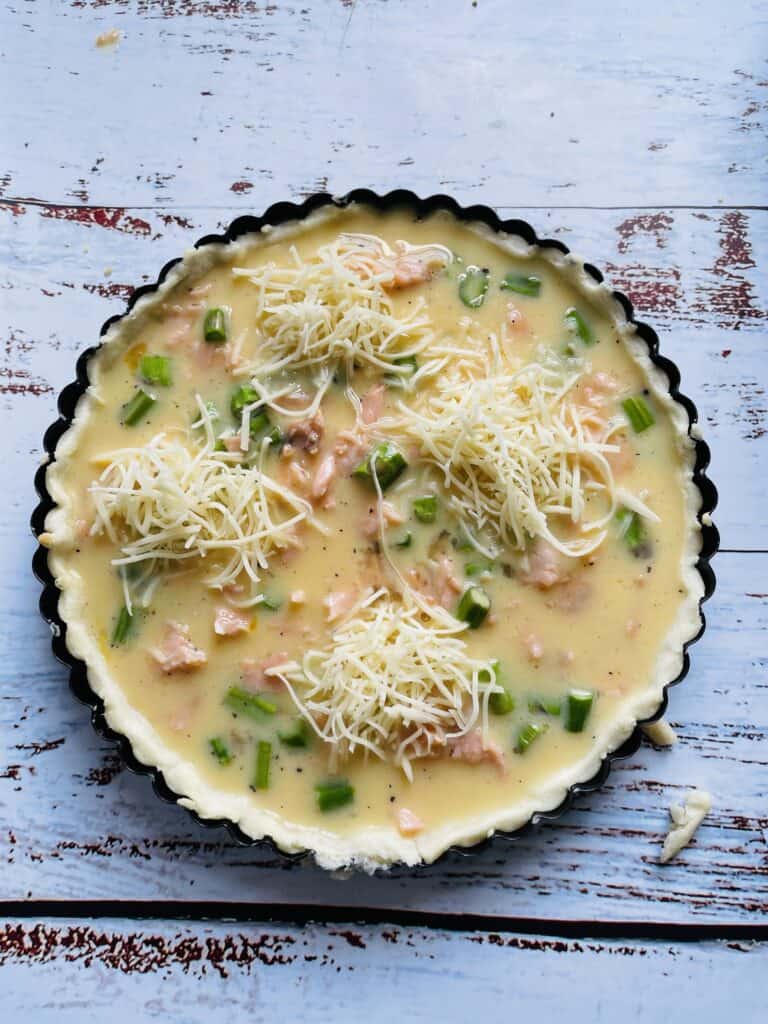 Unbaked quiche topped with Emmental